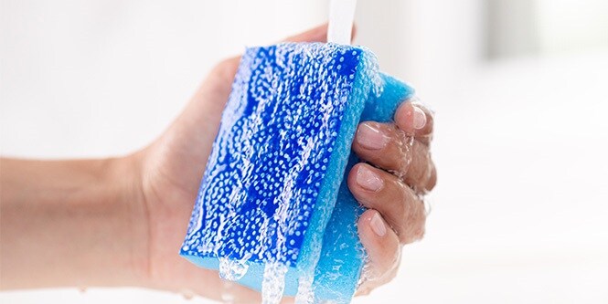 Femme nettoyant l’éponge non rayante Scotch-Brite® Fresh dans un évier
